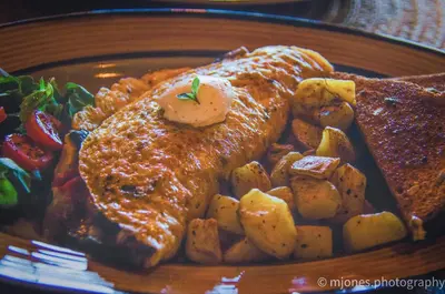 a plate of food with meat potatoes and toast at The Fraser River's Edge B&B Lodge in Chilliwack