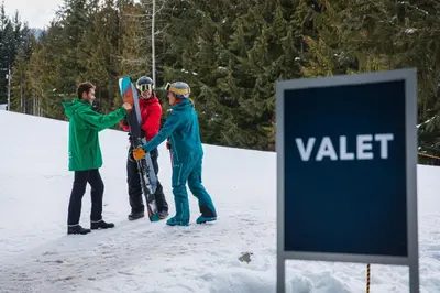 a group of people standing in the snow holding snowboards at Blackcomb Springs Suites by CLIQUE in Whistler