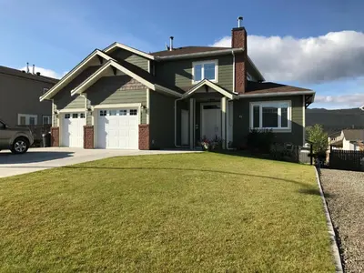 a green house with a large yard at 1st Choice Bed and Breakfast in Whitehorse