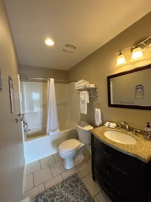 a bathroom with a toilet and a tub and a sink at Pacific Rim Guest Lodge - Adults Only in Ucluelet