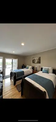 a bedroom with two beds and a couch at Pacific Rim Guest Lodge - Adults Only in Ucluelet