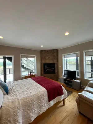 a bedroom with a large bed and a fireplace at Pacific Rim Guest Lodge - Adults Only in Ucluelet