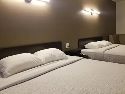 a hotel room with two beds with white pillows at Joys Inn Innisfail, AB in Innisfail