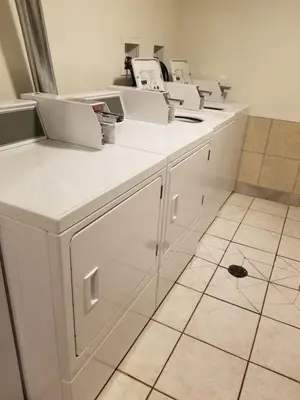 a kitchen with white cabinets with laptops on them at Joys Inn Innisfail, AB in Innisfail