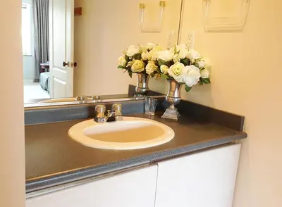 a bathroom sink with a vase of flowers on it at Harmony House in Richmond