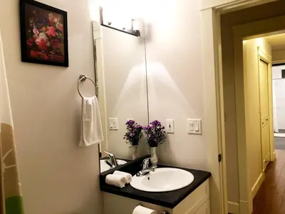 a bathroom with a sink and a mirror at Hannah's Heavenly Home in Surrey