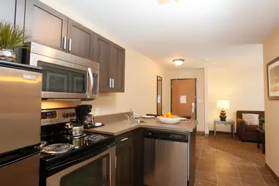 a kitchen with a sink and a stove top oven at Pomeroy Inn & Suites at Olds College in Olds