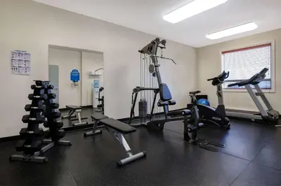 a gym with several tread machines in a room at Days Inn by Wyndham Dawson Creek in Dawson Creek
