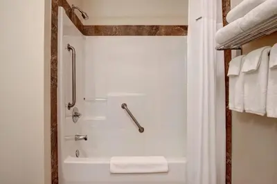 a bathroom with a shower and a white tub at Days Inn by Wyndham Dawson Creek in Dawson Creek