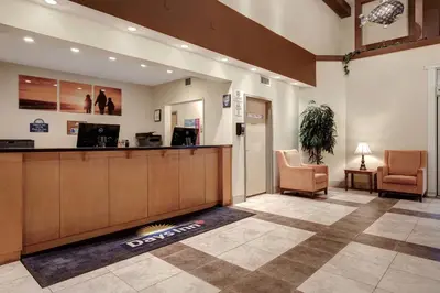 a hotel lobby with a reception desk and chairs at Days Inn by Wyndham Dawson Creek in Dawson Creek