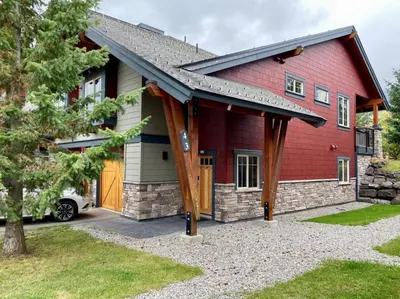 a red house with a car parked in front of it at Pinnacle Ridge by StayIn in Fernie
