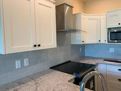a kitchen with white cabinets and a counter top at Botany Bay by Eagle Reach Properties in Port Renfrew