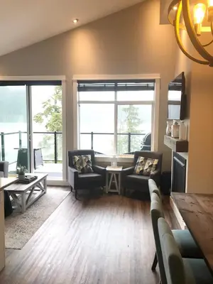 a living room with two couches and a table at Sandy Feet Retreat Port Renfrew- Oceanfront 2BR modern cottage in Port Renfrew