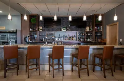 a bar in a restaurant with brown chairs at DoubleTree by Hilton - Kamloops in Kamloops