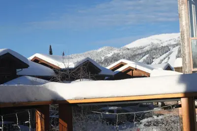 a snow covered roof of a building with mountains in the background at Woodhaven # 8 in Sun Peaks in Sun Peaks