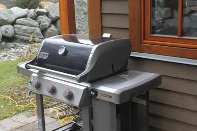 a grill sitting outside of a house next to a window at Woodhaven # 8 in Sun Peaks in Sun Peaks