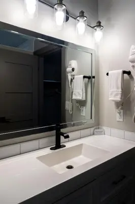 a bathroom with a sink and a large mirror at The Baker Hotel in Cranbrook