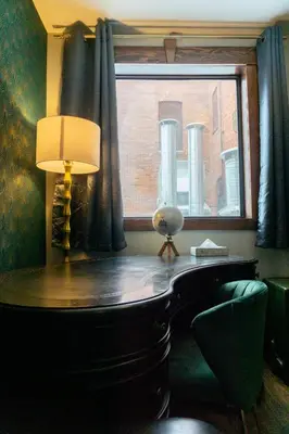 a desk with a lamp and a window at The Baker Hotel in Cranbrook