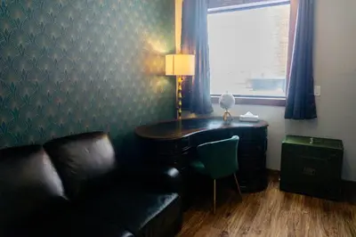 a living room with a piano and a couch at The Baker Hotel in Cranbrook