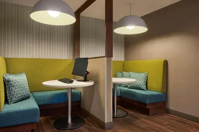 a waiting room with two tables and two chairs and a computer at Hampton Inn & Suites Kelowna, British Columbia, Canada in Kelowna