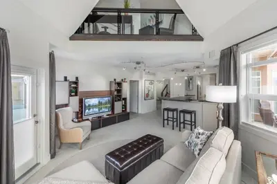 a living room with a couch and a kitchen at Kelowna Discovery in Kelowna