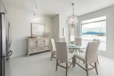 a dining room with a glass table and chairs at Kelowna Discovery in Kelowna