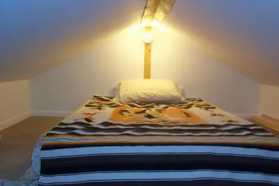 a bed with a blanket on it in a room at Cabine, Home Sweet Home in Whitehorse