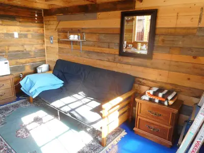 a room with a bed in a log cabin at Cabine, Home Sweet Home in Whitehorse