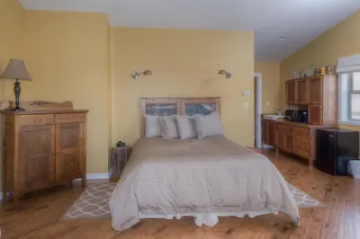 a bedroom with a large bed and a kitchen at Country Encounters Accommodations in Coleman