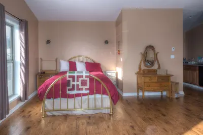a bedroom with a bed and a table and a mirror at Country Encounters Accommodations in Coleman