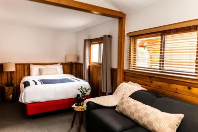 a bedroom with a bed and a couch and a window at Miette Mountain Cabins in Jasper