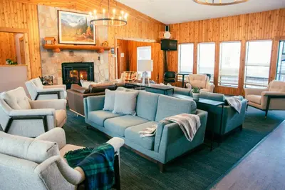 a living room with blue couches and a fireplace at Miette Mountain Cabins in Jasper