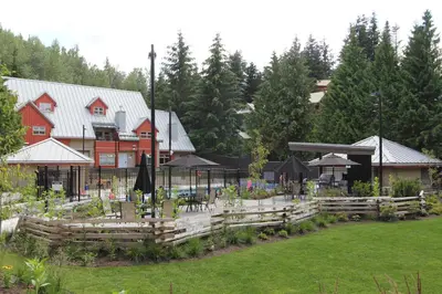 a house with a fence and a garden in front of it at Lake Placid Lodge by Whistler Retreats in Whistler