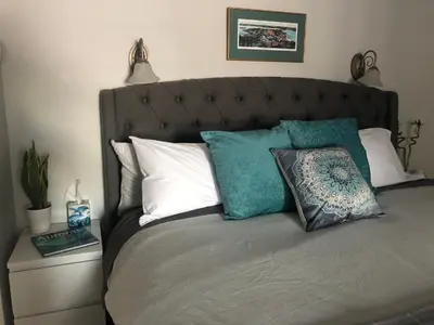 a bed with white and blue pillows on it at Great Slave Lakeside Bed & Breakfast in Yellowknife