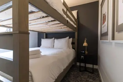a bed in a room with a loft bed at Basecamp Suites Canmore in Canmore
