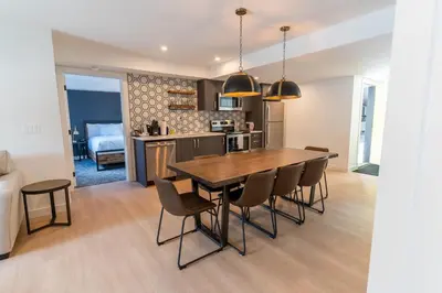 a kitchen and dining room with a wooden table and chairs at Basecamp Suites Canmore in Canmore