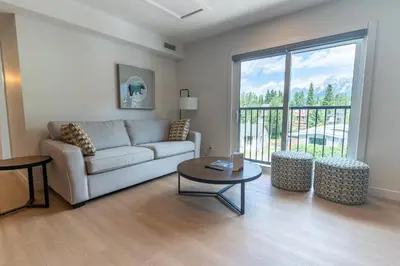 a living room with a couch and a table at Basecamp Suites Canmore in Canmore