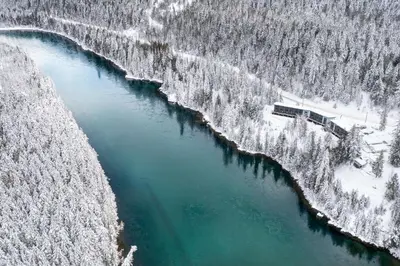 an aerial view of a river with snow covered trees at Basecamp Resorts Revelstoke in Revelstoke