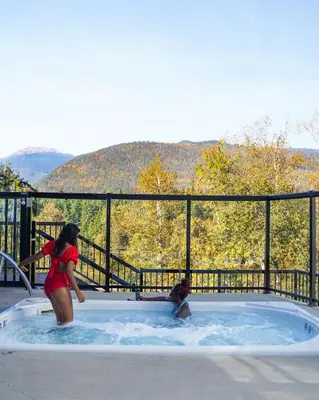 two women standing in a hot tub with a view at Basecamp Resorts Revelstoke in Revelstoke