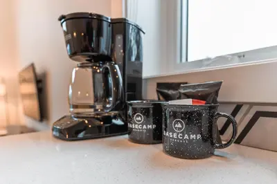 two coffee mugs sitting on a counter next to a coffee maker at Basecamp Resorts Revelstoke in Revelstoke