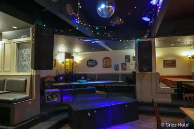 a room with a bar with a table and speakers at Grizz Hotel in Revelstoke