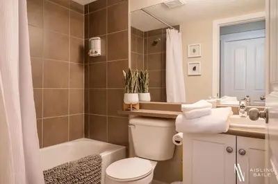 a bathroom with a toilet and a tub and a sink at Rustic Modern 2 Bed 2 Bath with Lakeview Pool and Hot Tub in Invermere