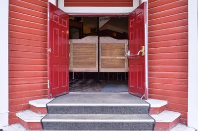 an open door of a red house with a bedroom at The Downtown, a Coast Hotel in Dawson City
