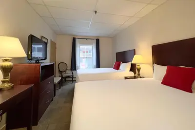 a hotel room with two beds and a television at The Downtown, a Coast Hotel in Dawson City