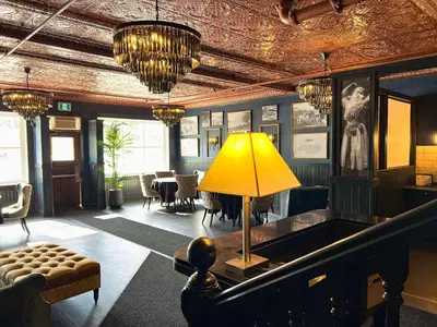 a living room with a table and a yellow lamp at Midnight Sun, a Coast Hotel in Dawson City