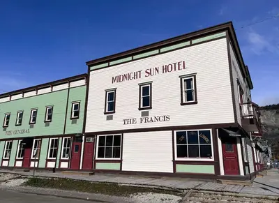 a large white building with thefamous six inch hotel at Midnight Sun, a Coast Hotel in Dawson City