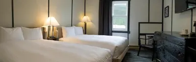a hotel room with two beds and a window at Midnight Sun, a Coast Hotel in Dawson City