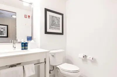 a white bathroom with a toilet and a sink at Four Points by Sheraton Kelowna Airport in Kelowna