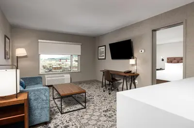 a hotel room with a couch and a desk at Four Points by Sheraton Kelowna Airport in Kelowna