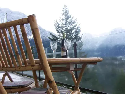 a wooden bench with a bottle of wine and two glasses at High Hopes Bed and Breakfast in Hope